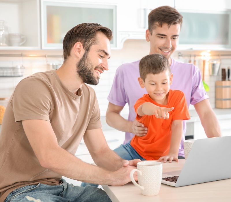 Male gay couple with foster son spending time together at home. Adoption concept